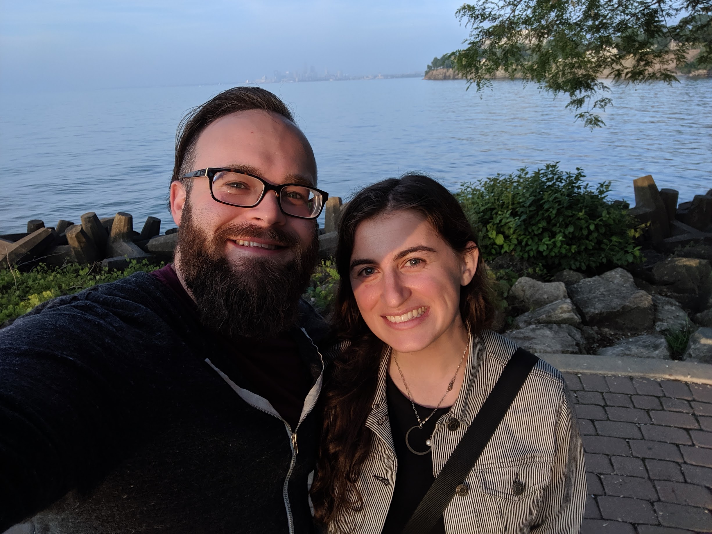 photo of brad (left) and claire (right) at sunset with the Cleveland skyline in the background